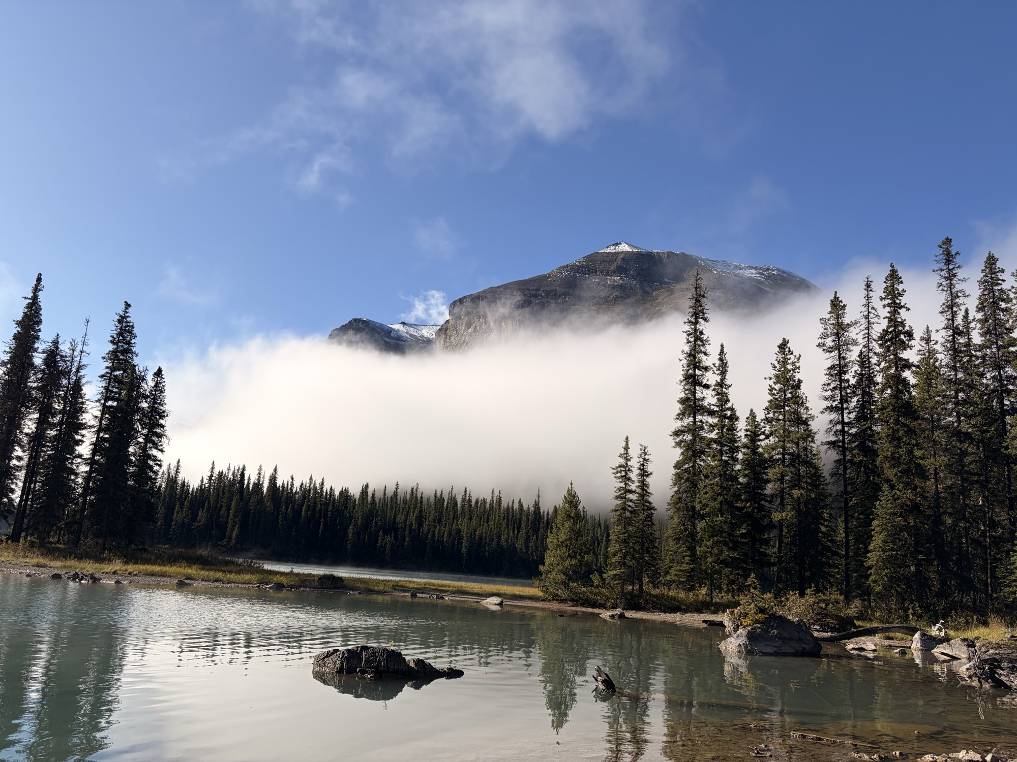 Mountain, mist, and forest reflected in a lake